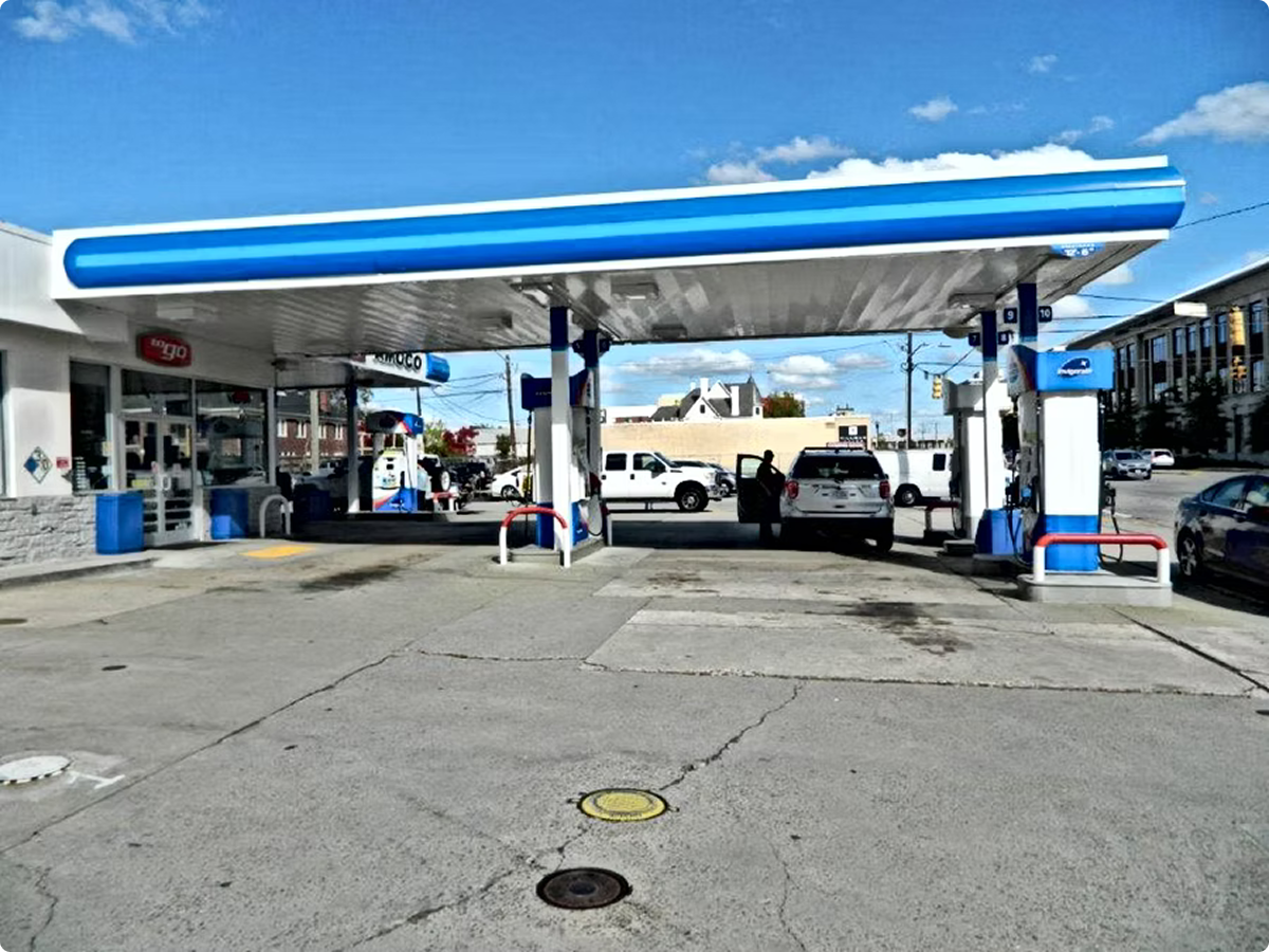 Vehicles at gas pumps under canopy